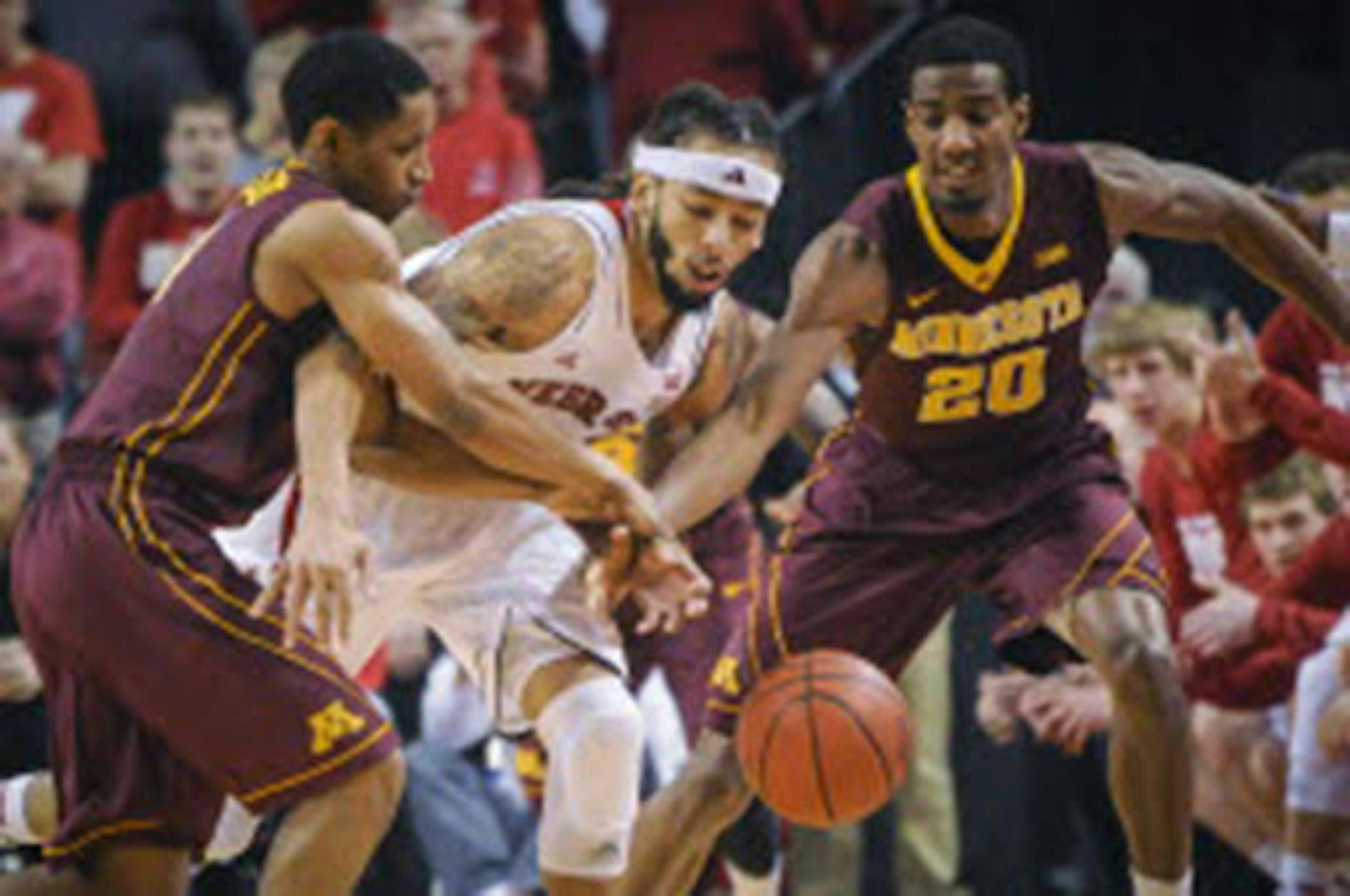 Cornhuskers guard/forward Terran Petteway (5) scrambled for a loose ball with Gophers guard Austin Hollins (20) during Nebraska's 82-78 victory Sunday in Lincoln, Neb. Petteway led all scorers with 35 points.