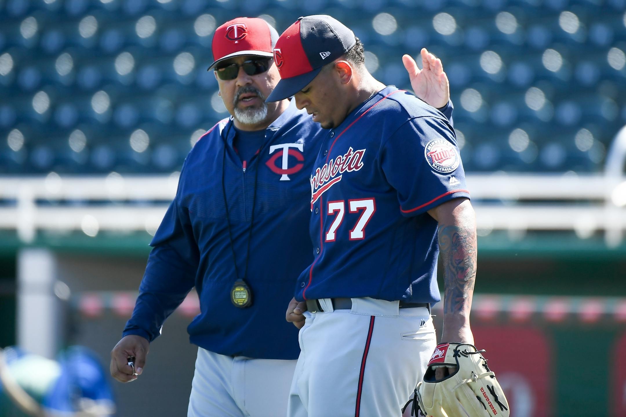 Minnesota Twins bullpen coach Eddie Guardado (18) patted pitching prospect Fernando Romero (77) on the back after Romero finished pitching during live batting practice Monday.