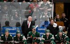 Minnesota Wild coach Bruce Boudreau watches the final minutes against the Boston Bruins with his players on the bench during an NHL hockey game Saturd