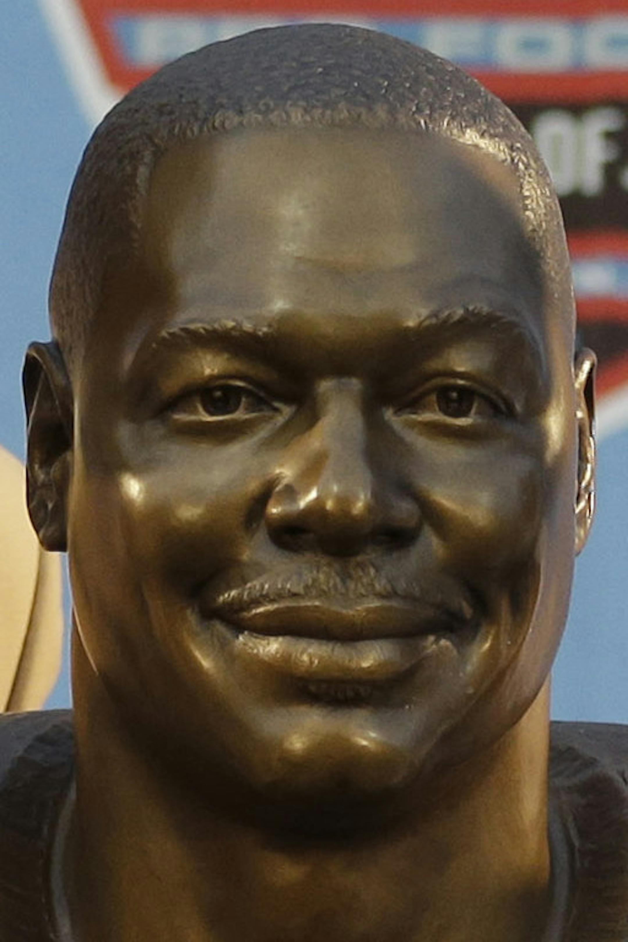 Hall of Fame Inductee Derrick Brooks, left, with his son, presenter Decalon Brooks, pose with the bust during the 2014 Pro Football Hall of Fame Enshrinement Ceremony at the Pro Football Hall of Fame Saturday, Aug. 2, 2014, in Canton, Ohio. (AP Photo/Tony Dejak)