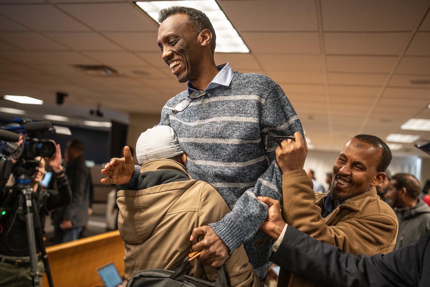 Eid Ali, President of the Minnesota Uber &Lyft Driver’s Association was lifted up by drivers after the Minneapolis City Council approves rideshare drive pay hike Thursday, Feb. 7, 2024 at Minneapolis City Council in Minneapolis, Minn. The plan approved Thursday guarantees a floor of $1.40 per mile and 51 cents per minute.] JERRY HOLT • jerry.holt@startribune.com