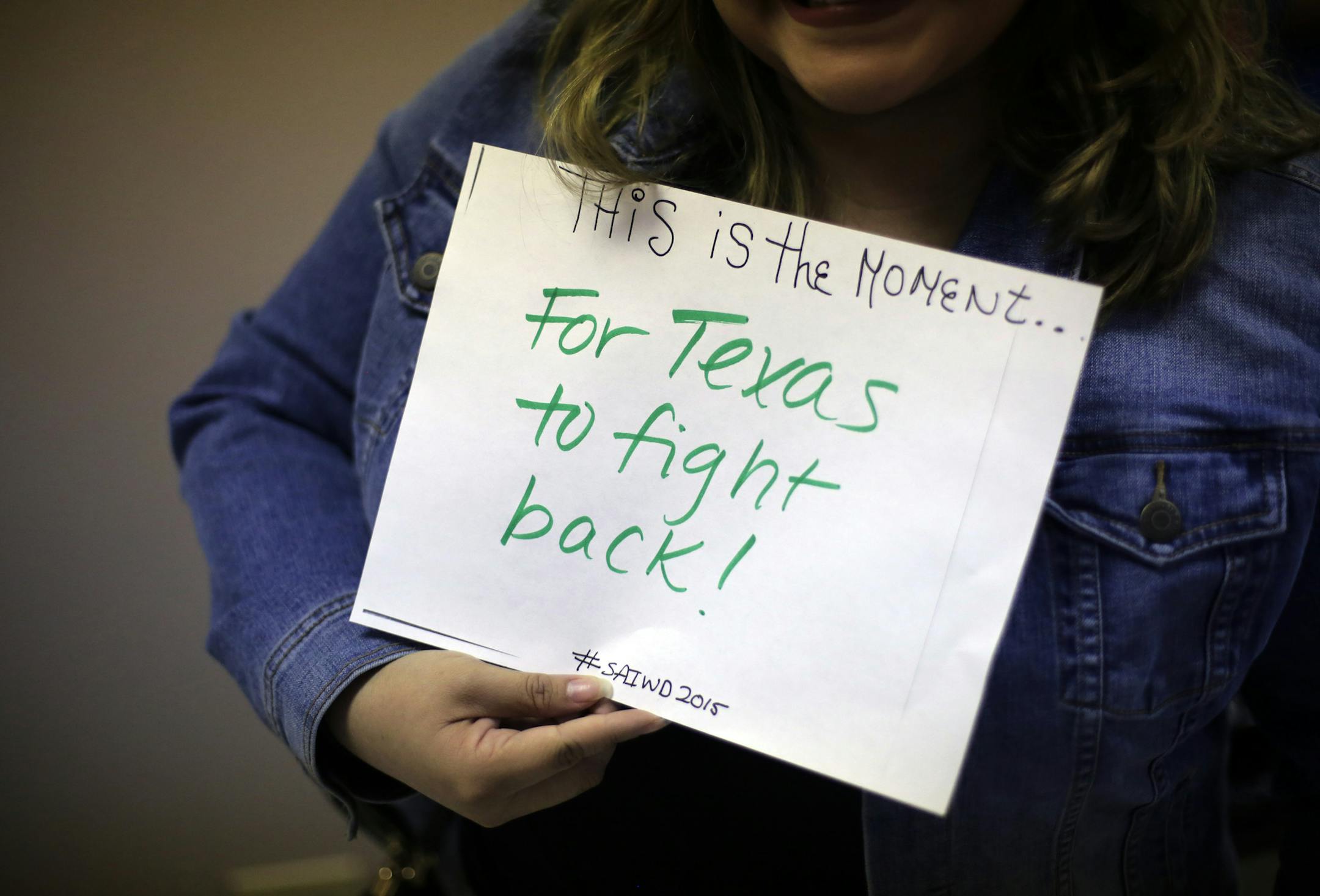 Giovanna Valverde poses for a photo with her sign during a gathering at Whole Womanís Health of San Antonio, Tuesday, Feb. 9, 2016, in San Antonio. The Supreme Court will soon hear Whole Woman's Healthís challenge to HB2, Texas legislation that requires all abortion facilities to meet heightened requirements by becoming ambulatory service centers. (AP Photo/Eric Gay)