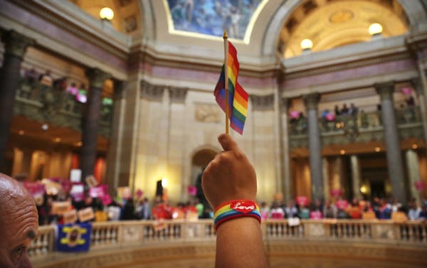 A supporter of gay marriage, waved the pride flag before the historic Minnesota House vote to legalize same-sex marriage.