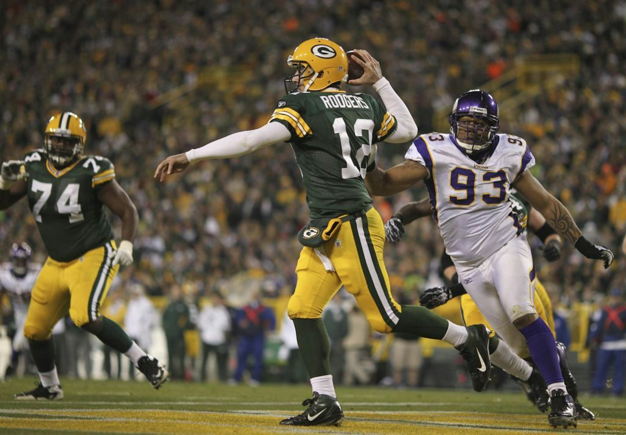 Packers quarterback Aaron Rogers while under pressure from the Vikings' Kevin Williams in 2011.