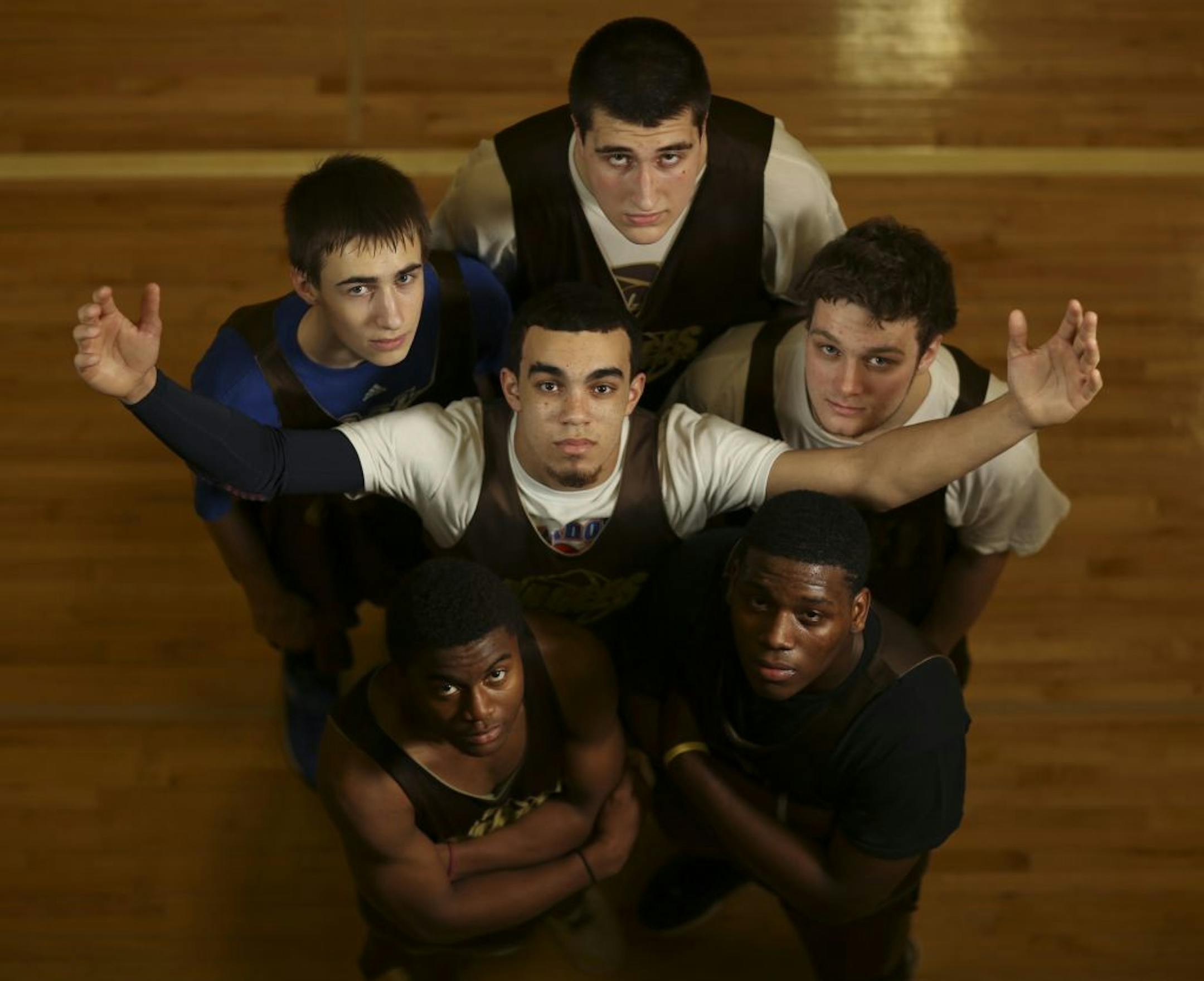 Tyus Jones surrounded by, clockwise from lower left, Harry Sonie, Robert Tobroxen, Brock Bertram, Dustin Fronk, and Dennis Austin after a practice.