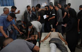 Palestinians, who were injured last night while trying to get access to humanitarian aid, arrive at the al-Shifa Hospital, in Gaza City, Wednesday, Ju