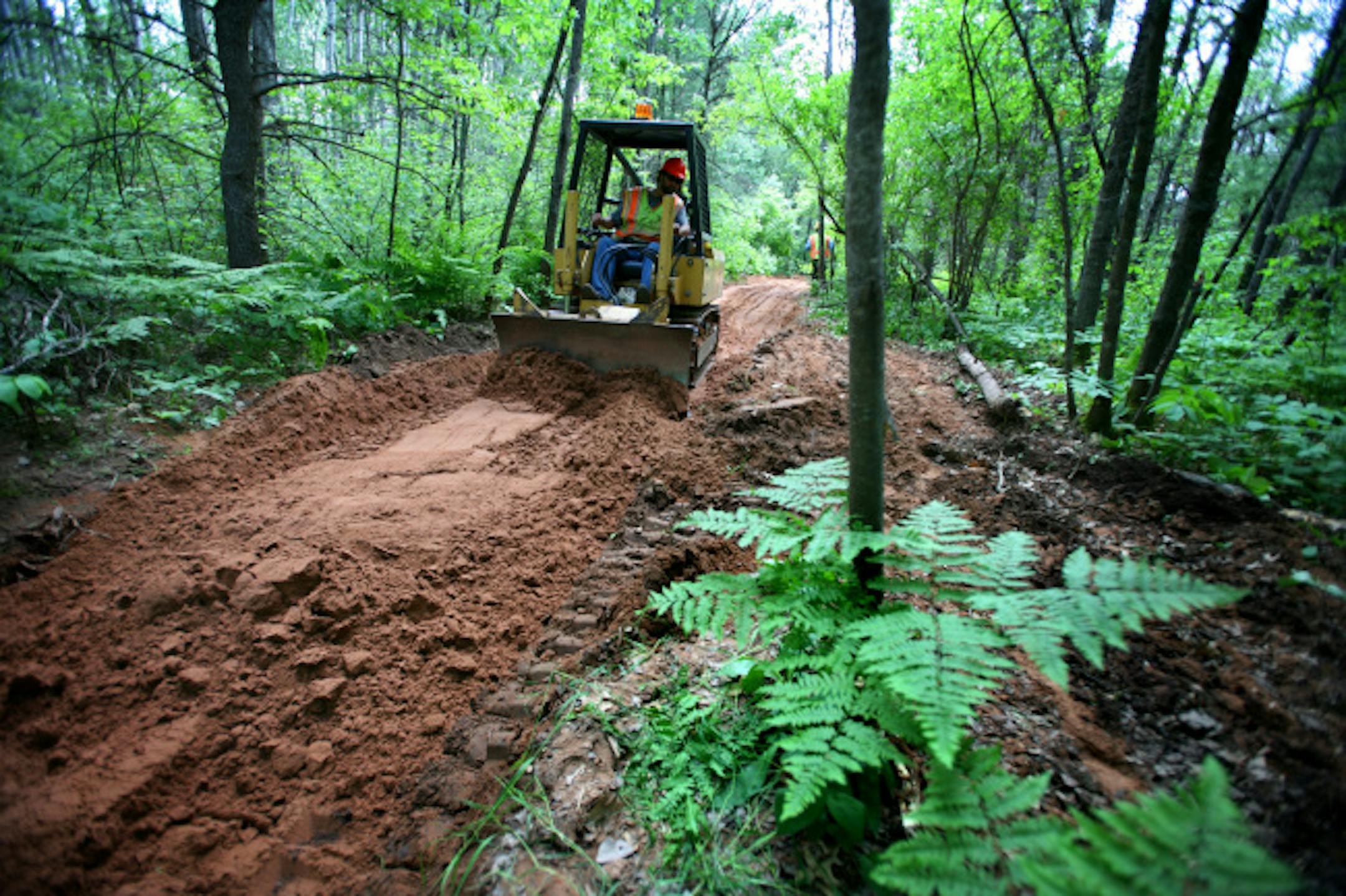 The Red Top trail in north central Minnesota is a popular spot for ATV's. It's 25 miles contains an adventure trail and sink-hole where riders can challenge their machines. Since 2002 the DNR has spent over $200,000 to repair damage on the Red Top, but it has no estimate of how much it will cost to maintain the 6,000 miles of trails in the new system. (in this photo)DNR crews work on trail repair on the General Andrews State Forest Trail near Willow River.
