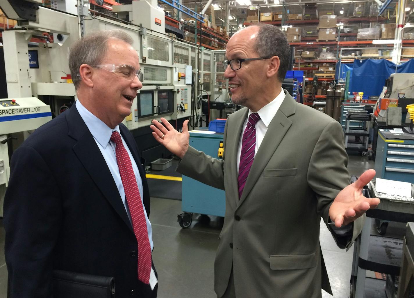 Chuck Rescorla, Graco's vice president of corporate manufacturing, visits Wednesday with U.S .Secretary of Labor Thomas Perez at Graco's flagship plant on the Mississippi River in northeast Minneapolis about how the company partners with area community colleges to fill skilled entry-level jobs that pay around $20 an hour plus benefits .