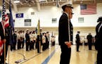 Washington Technology Magnet School Navy junior ROTC Honor Guard member James Vo, a junior, rear left, holds two flags as fellow Honor Guard members r