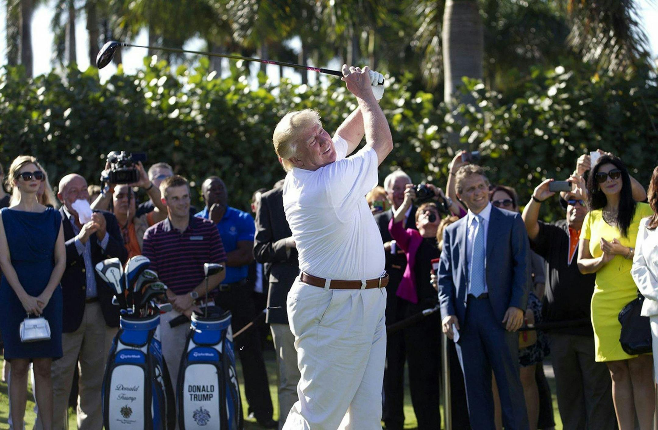 Donald Trump hits a ceremonial tee shot off the first tee at Trump National Doral, February 6, 2014, in Doral, Fla. Trump says he is reversing his plan to hold the next Group of Seven world leaders' meeting at his golf resort.
