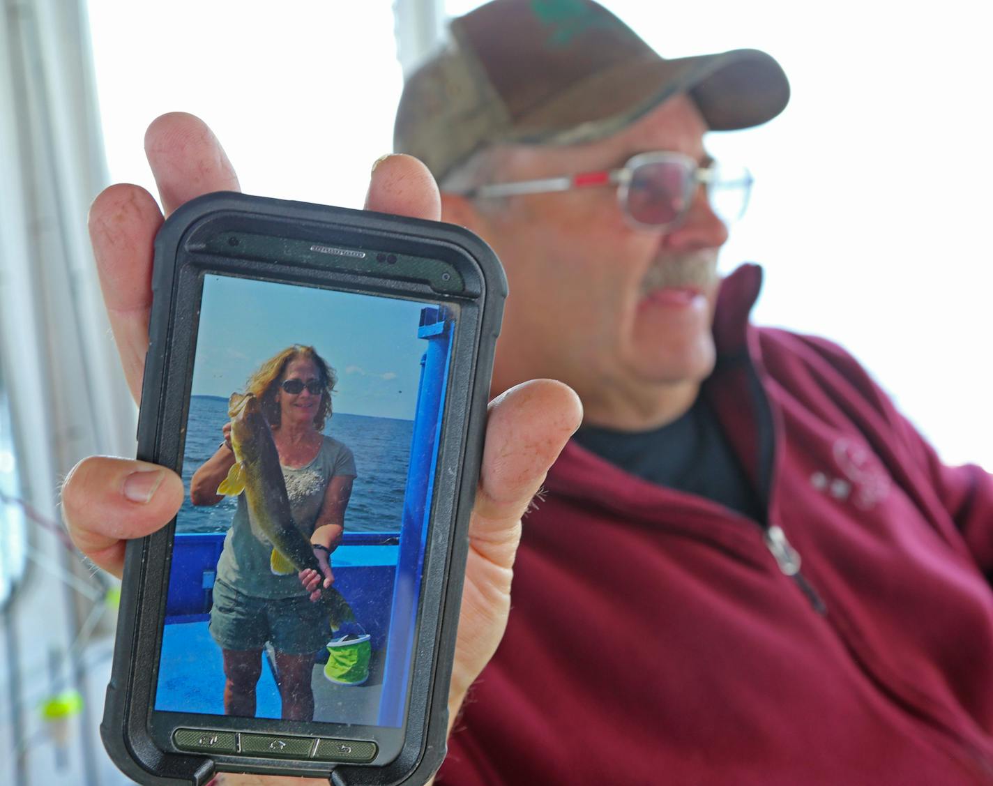 Launch fishing guide Mike Lencowski holds up a cell phone photo of one of his many clients this summer who caught big walleyes on Mille Lacs. "Some days the big ones bite, some days the small ones,'' he said. Fishing generally has been good, especially in the evenings, when often more than 100 walleyes are caught on his Twin Pines Resort launch. Most are outside the 19-21 inch protected slot, and are released.