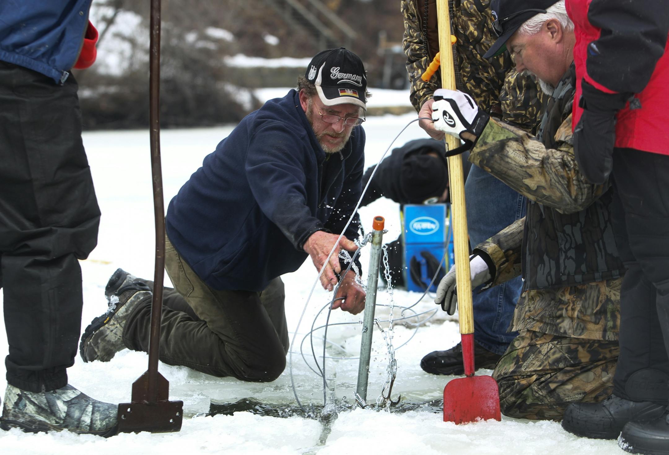 Kira Trevino's cousin, Mike Teige, for the second day, showed up at Keller Lake to search for Kira's body. Here, he is seen pulling up a drag line. Other volunteers followed suit Saturday, March 30, 2013, to help Teige look as literally hundreds of small holes were drilled into Keller Lake and a chainsaw was used to strategically cut out slits in the ice in which to use a line with hooks to drag areas of the lake to try and hook and recover Trevino's body - believed by some to have been dumped i