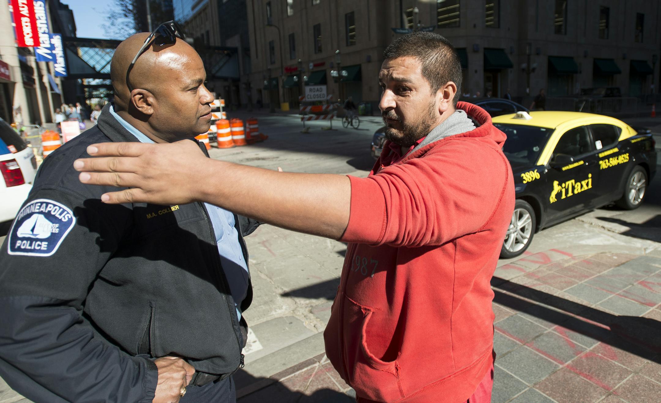 Cab driver Walter Mendez, right, argued with a Minneapolis Police officer after receiving a ticket for obstructing traffic at 7th Street and Nicollet Tuesday afternoon. Police urged taxi drivers to move their protest to City Hall. ] Aaron Lavinsky • aaron.lavinsky@startribune.com Dozens of cabs clogged traffic along 7th street in downtown Minneapolis in what police are calling civil disobedience on Tuesday, Oct. 13, 2015. Drivers are upset with downtown hotels and believe they are cutting
