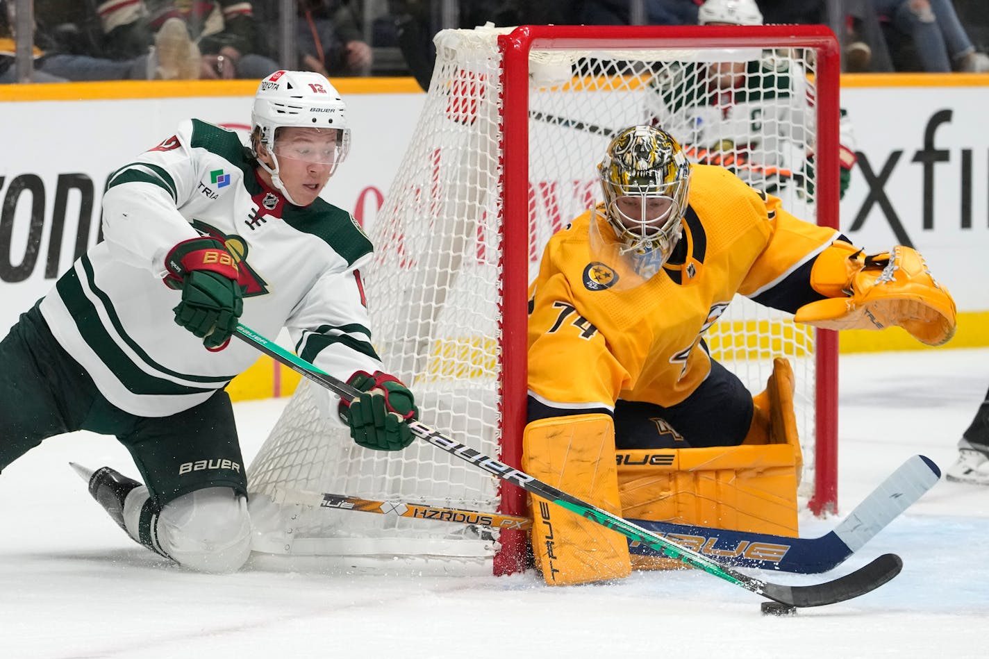 Minnesota Wild's Matt Boldy (12) tries to get a show away against Nashville Predators goaltender Juuse Saros (74) in the third period of an NHL hockey game Tuesday, Nov. 15, 2022, in Nashville, Tenn. (AP Photo/Mark Humphrey)