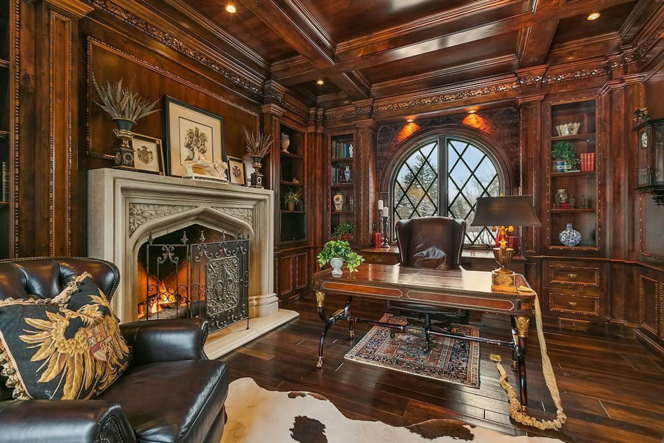 The office features a fireplace and floor-to-ceiling woodwork.