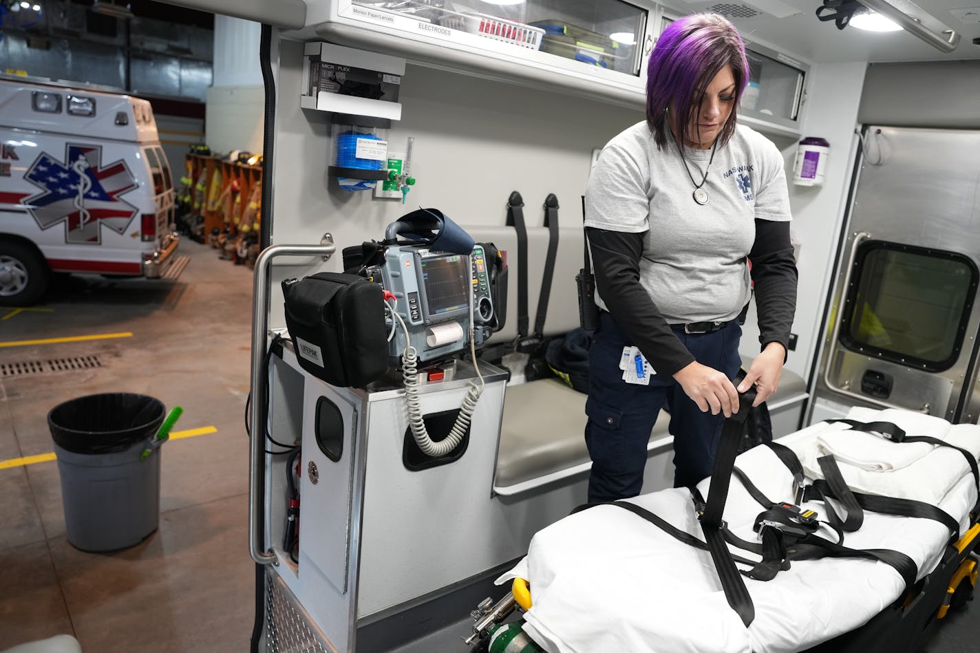 Rikki Ciatti, an EMT with Nashwauk's ambulance service arranges straps on a stretcher as she resupplies her rig after returning from responding to a 911 call Friday, Dec. 1, 2023 in Nashwauk, Minn. ] ANTHONY SOUFFLE • anthony.souffle@startribune.com