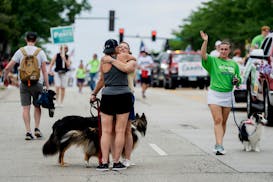 Erin Cartwright Weinstein, clerk of the circuit court of Lake County, receives a hug during the Independence Day Parade along Central Avenue in Highla
