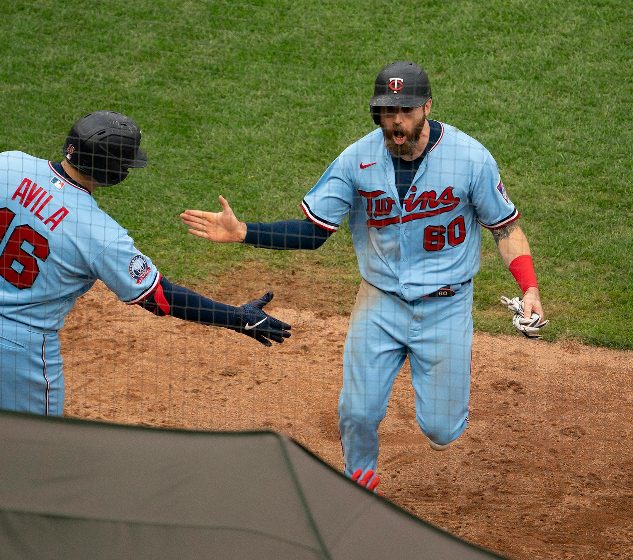 Minnesota Twins catcher Alex Avila (16) congratulated center fielder Jake Cave (60) after the home plate umpire sent Cave home from third base on a balk by Cincinnati Reds starting pitcher Sonny Gray in the fifth inning.