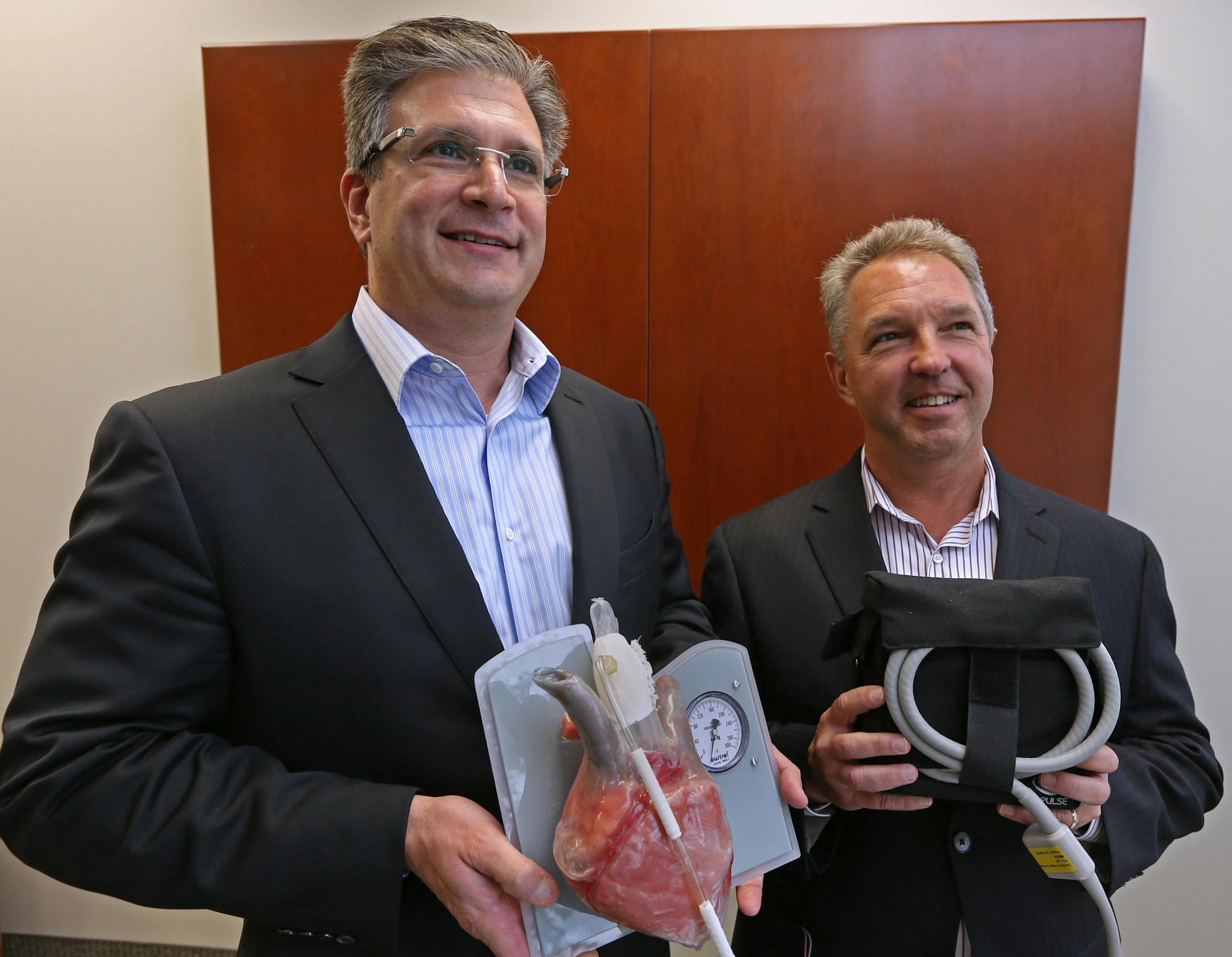 (left to right) Sunshine Heart's Dave Rosa, CEO and Jeff Mathiesen, CFO were photographed on 10/22/13 with the C-Pulse Heart Assist System. Feature on Sunshine Heart, a local company beginning U.S. trials for a device that helps the heart pump blood for patients with heart failure. They recently raised $46 million through a stock sale and are getting closer to a commercial release.] Bruce Bisping/Star Tribune bbisping@startribune.com Dave Rosa, Jeff Mathiesen/source.