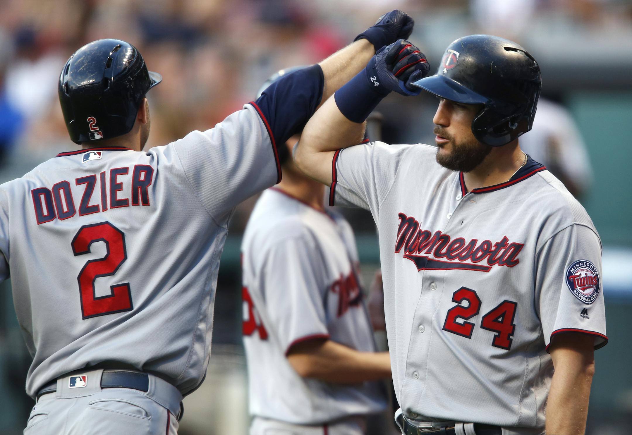 Minnesota Twins' Brian Dozier (2) gets congratulations from Trevor Plouffe (24) after hitting a solo home run off Cleveland Indians starting pitcher Josh Tomlin during the first inning of a baseball game Tuesday, Aug. 30, 2016, in Cleveland. (AP Photo/Ron Schwane)