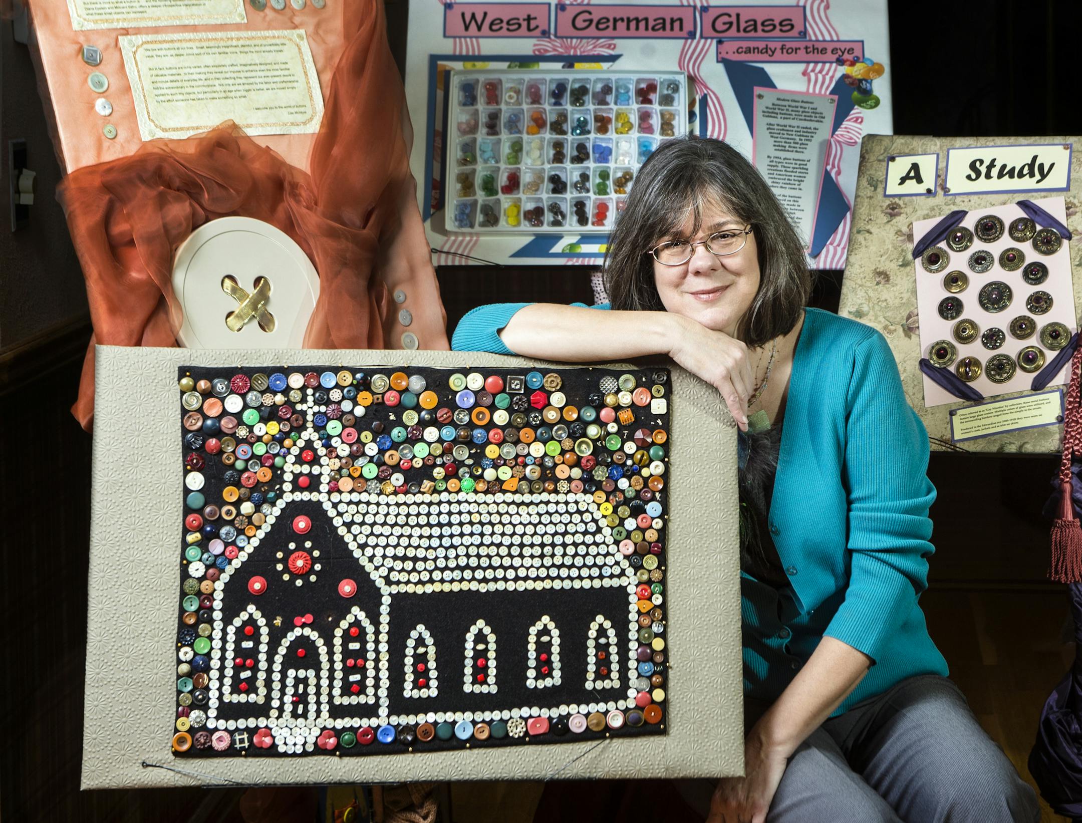 Lise McIntyre is surrounded by some of the buttons she uses in her Traveling Button Museum, including the first collection -- the church design piece -- she purchased more than 20 years ago. (Allison Long/Kansas City Star/TNS) ORG XMIT: 1164687