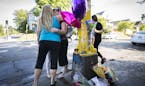 Those who identified only as extended members of the family of Sheryl and Kenneth Carpentier, two of the victims, hugged after putting up balloons and