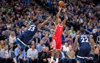 The Rockets' Trevor Ariza shot under pressure from Wolves guard Jimmy Butler (23) and Andrew Wiggins in the third quarter in Game 3 Saturday at Target