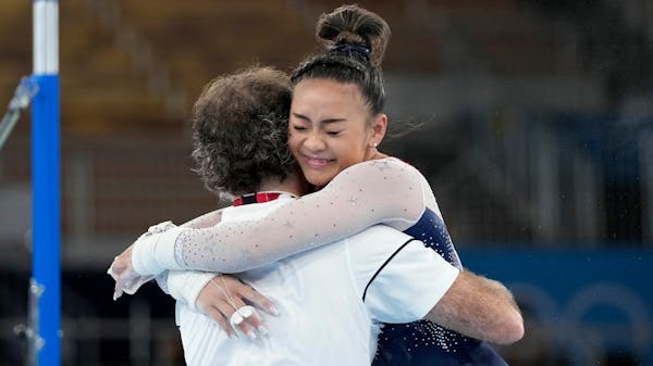 Suni Lee hugging her coach Jess Graba after her uneven bars routine in the women’s all-around competition.