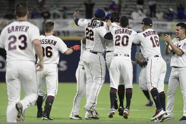 The Minnesota Twins celebrate a 2-1 win over the Cleveland Indians in 16 innings in a baseball game at Hiram Bithorn Stadium in San Juan, Puerto Rico,