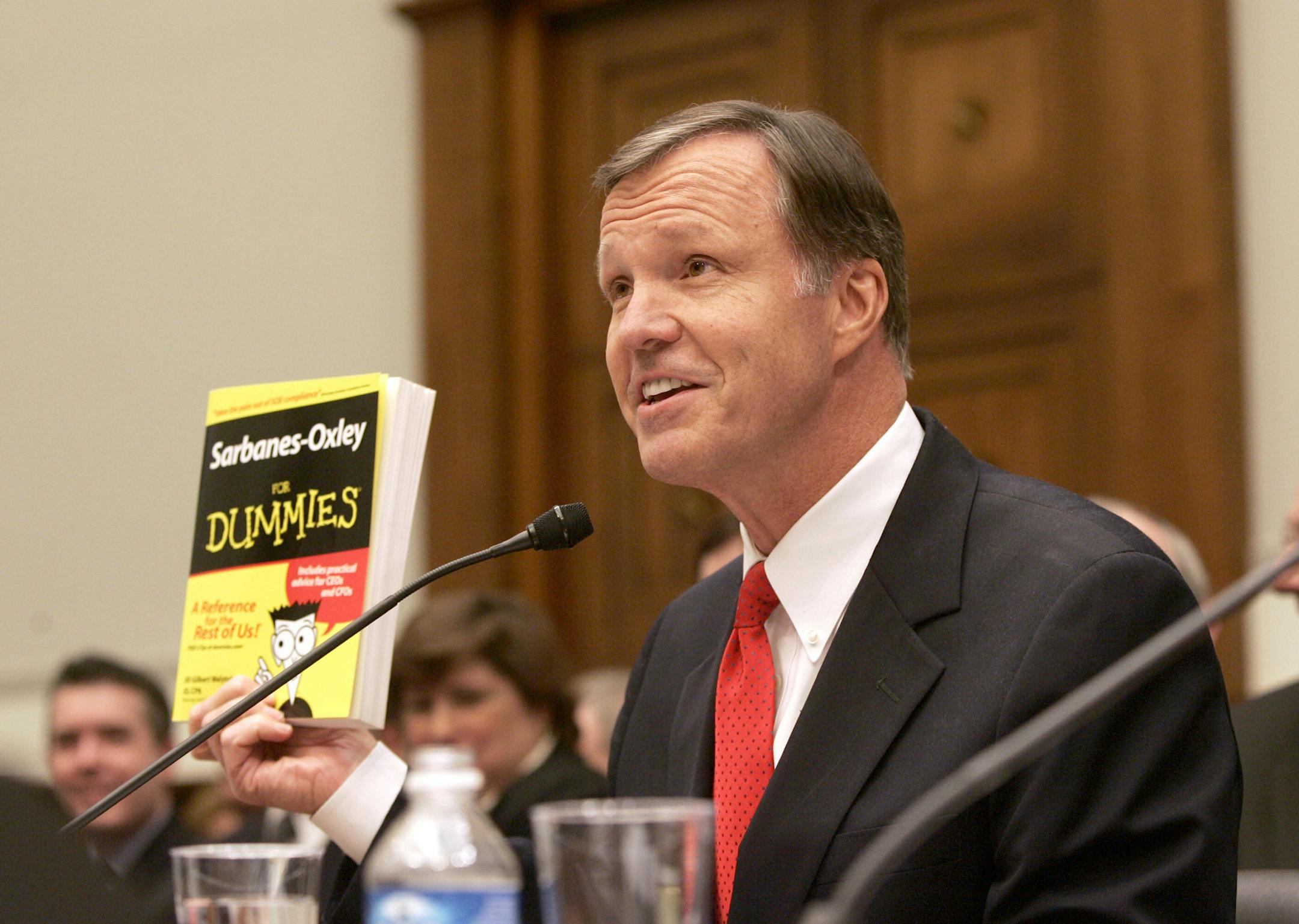 Securities and Exchange Commission Chairman Christopher Cox holds up a copy of the "Sarbanes-Oxley for Dummies" while testifying on Capitol Hill in Washington, Tuesday, Sept. 19, 2006 before the House Financial Services Committee. (AP Photo/Lawrence Jackson) ORG XMIT: DCLJ107
