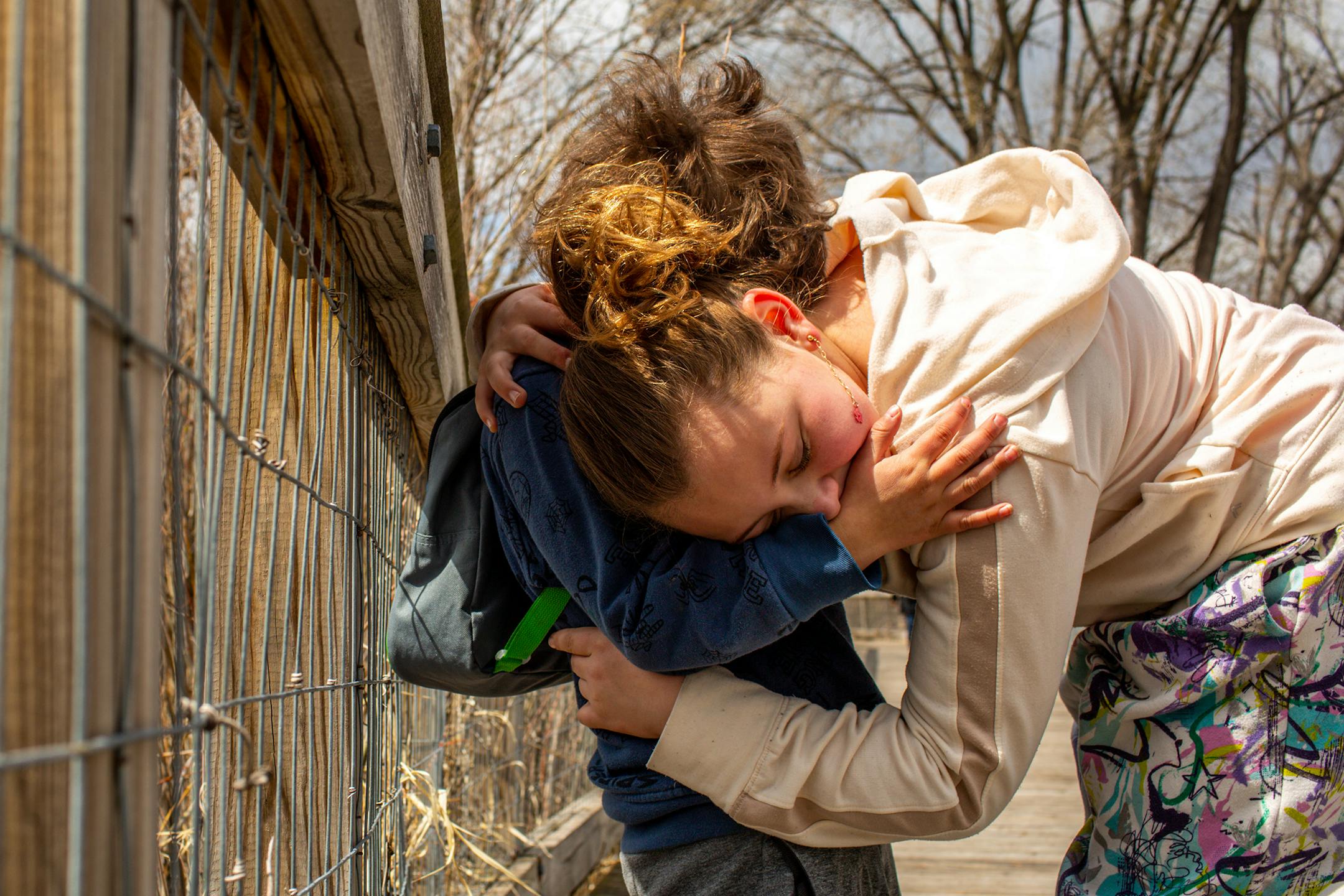 Issabella Collins, 9, spontaneously hugs her little brother Jordan Collins, 4, as they look at geese and pelicans in Keller Lake on Sunday, April 23, 2023, during a period of high spring flooding in Maplewood.