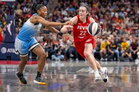 Indiana Fever guard Caitlin Clark (22) makes a move around the defense of Chicago Sky guard Lindsay Allen, left, during a WNBA basketball game Saturda
