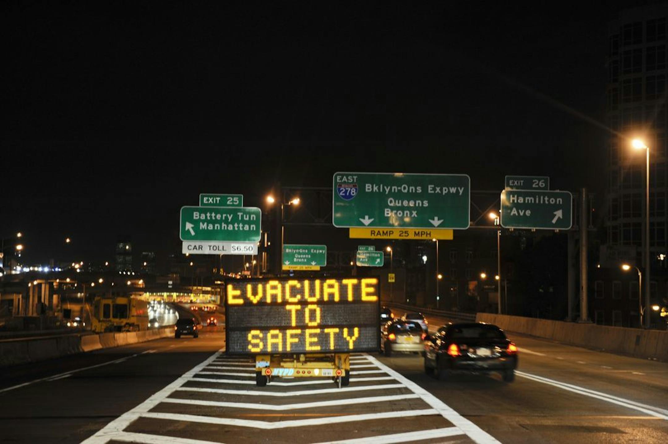 A sign along the Brooklyn-Queens Expressway near the Brooklyn Battery Tunnel advises residents to evacuate the city as Hurricane Irene begins to strike the East Coast, in New York, Aug. 26, 2011. The first punch from Hurricane Irene landed here on Friday, foreshadowing with brutal authority what is to come as this vast storm, its most forceful winds stretching outward for 90 miles, churned north toward New York