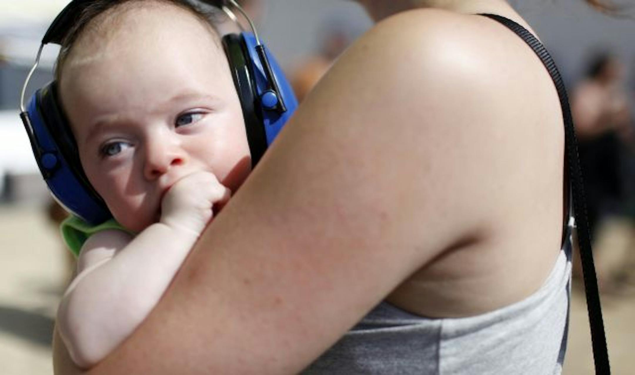 Four month-old Dylan Wohlhueter of Minneapolis sports a pair of protective headphones as the band Solid Gold performs during the Rock the Garden concert Saturday afternoon at the Walker Art Center in Minneapolis.