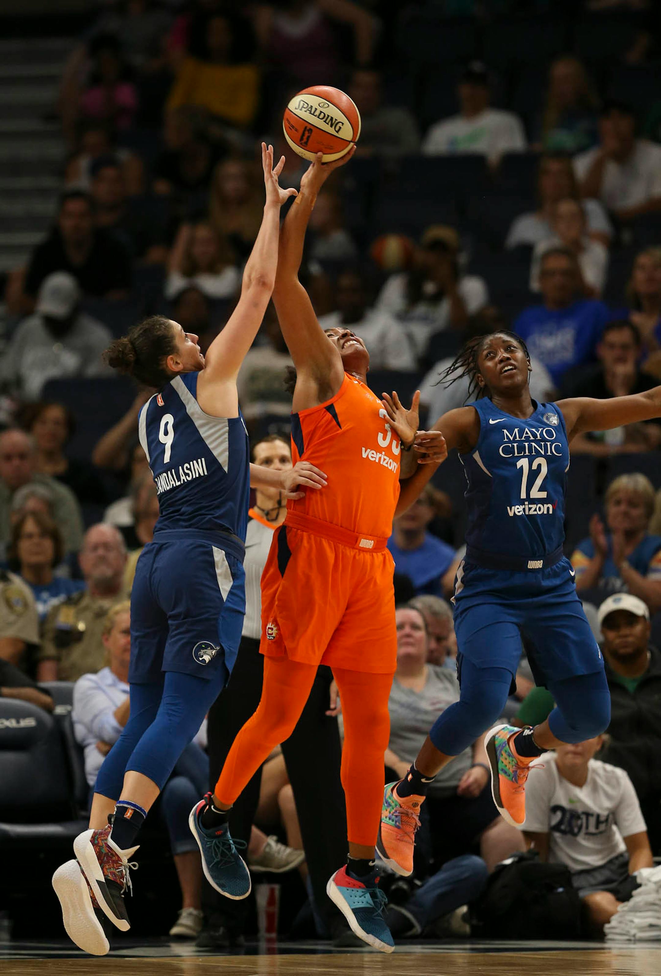 Connecticut Sun forward Morgan Tuck (33), who led all scorers with 15 points, was defended by Lynx forward Cecilia Zandalasini (9) and guard Alexis Jones (12) in the fourth quarter.