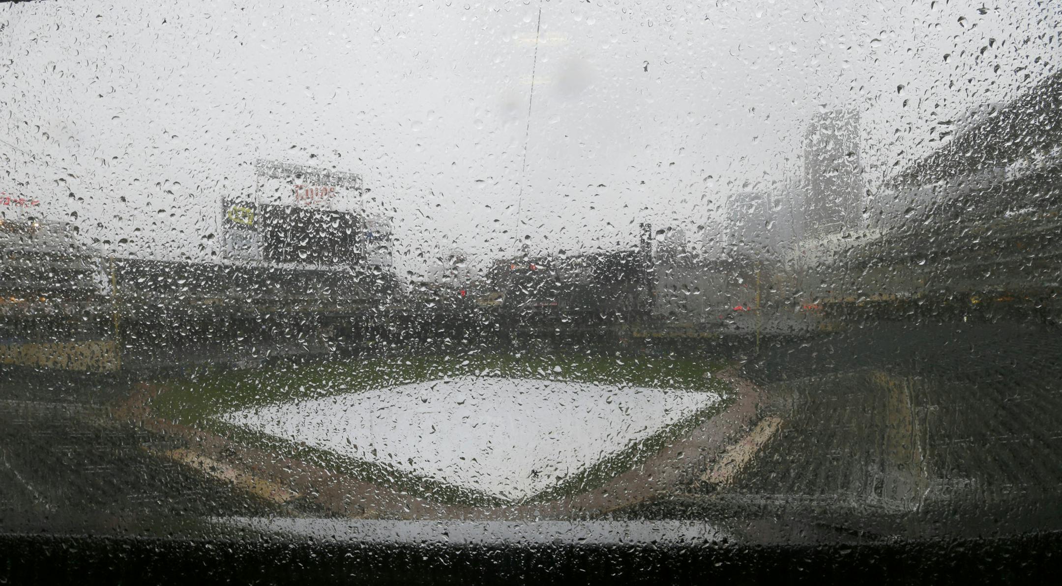 Rain falls on the tarp-covered field as the Minnesota Twins baseball game against the Detroit Tigers in Minneapolis, Sunday, April 27, 2014, is postponed due to the weather. (AP Photo/Ann Heisenfelt)