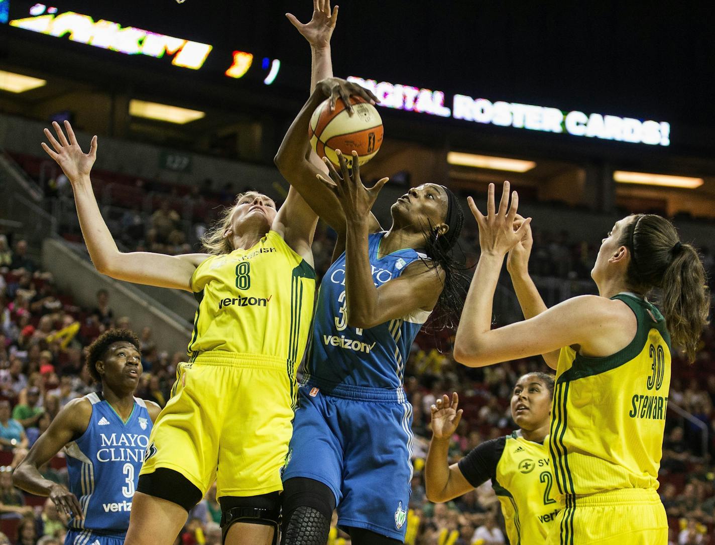 Lynx center Sylvia Fowles (34) comes up with the defensive board next to Seattle Storm's Carolyn Swords (8) and Breanna Stewart (30)