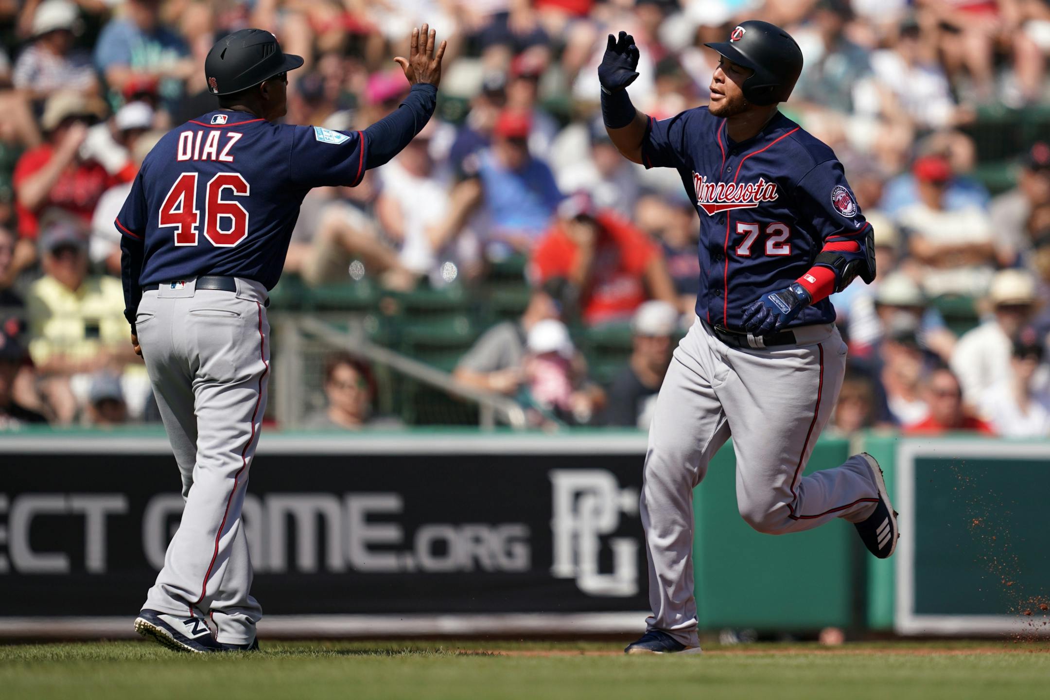 Minnesota Twins third baseman Randy Cesar (72) celebrated with Minnesota Twins third base coach Tony Diaz (46) as he rounded the bases after hitting a home run during Sunday's game.