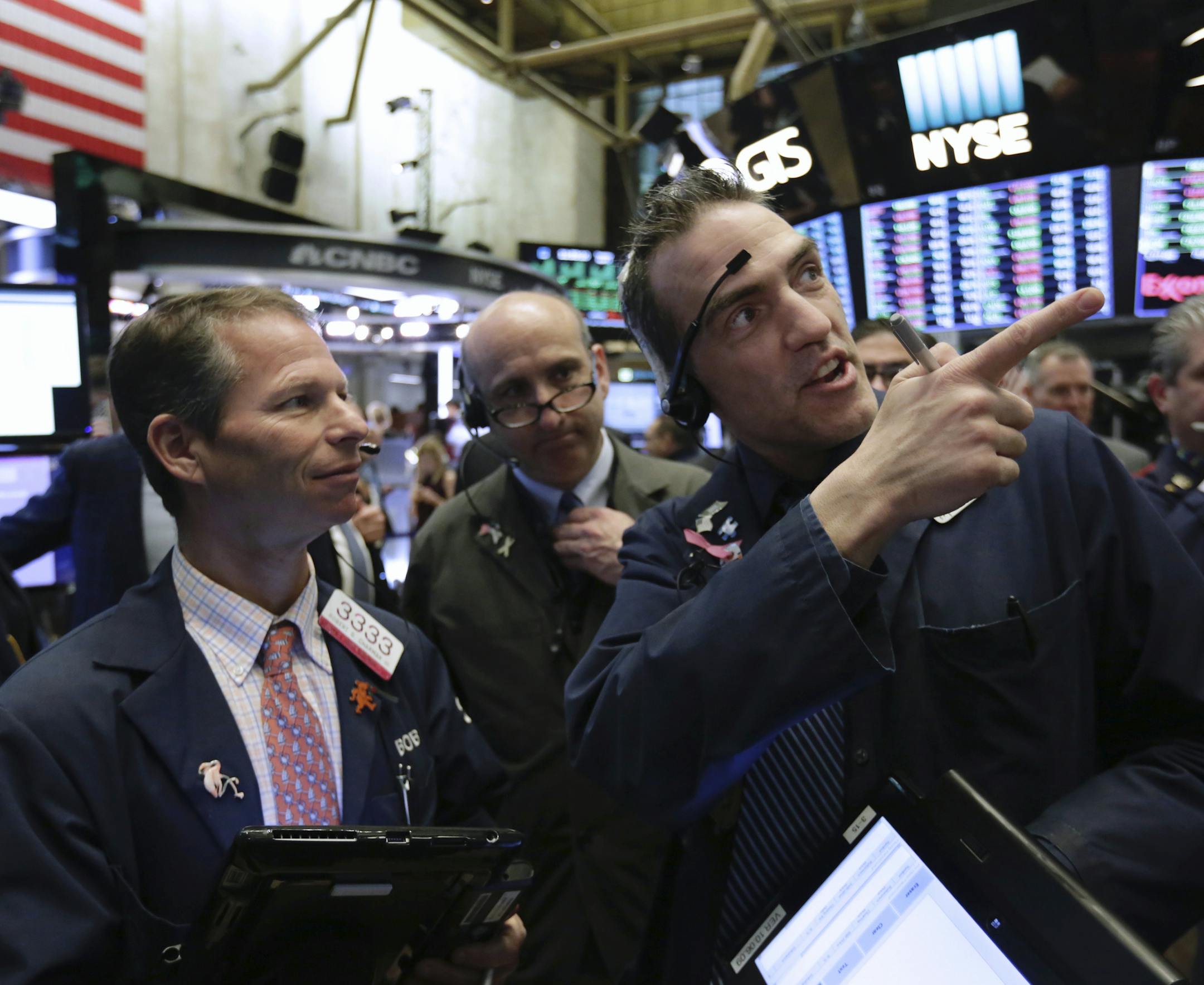 Gregory Rowe, right, speaks on the floor of the New York Stock Exchange while waiting for Spotify's IPO, Tuesday, April 3, 2018. Spotify Inc. will make its stock market debut Tuesday, casting a spotlight on its early lead in music streaming. (AP Photo/Richard Drew)