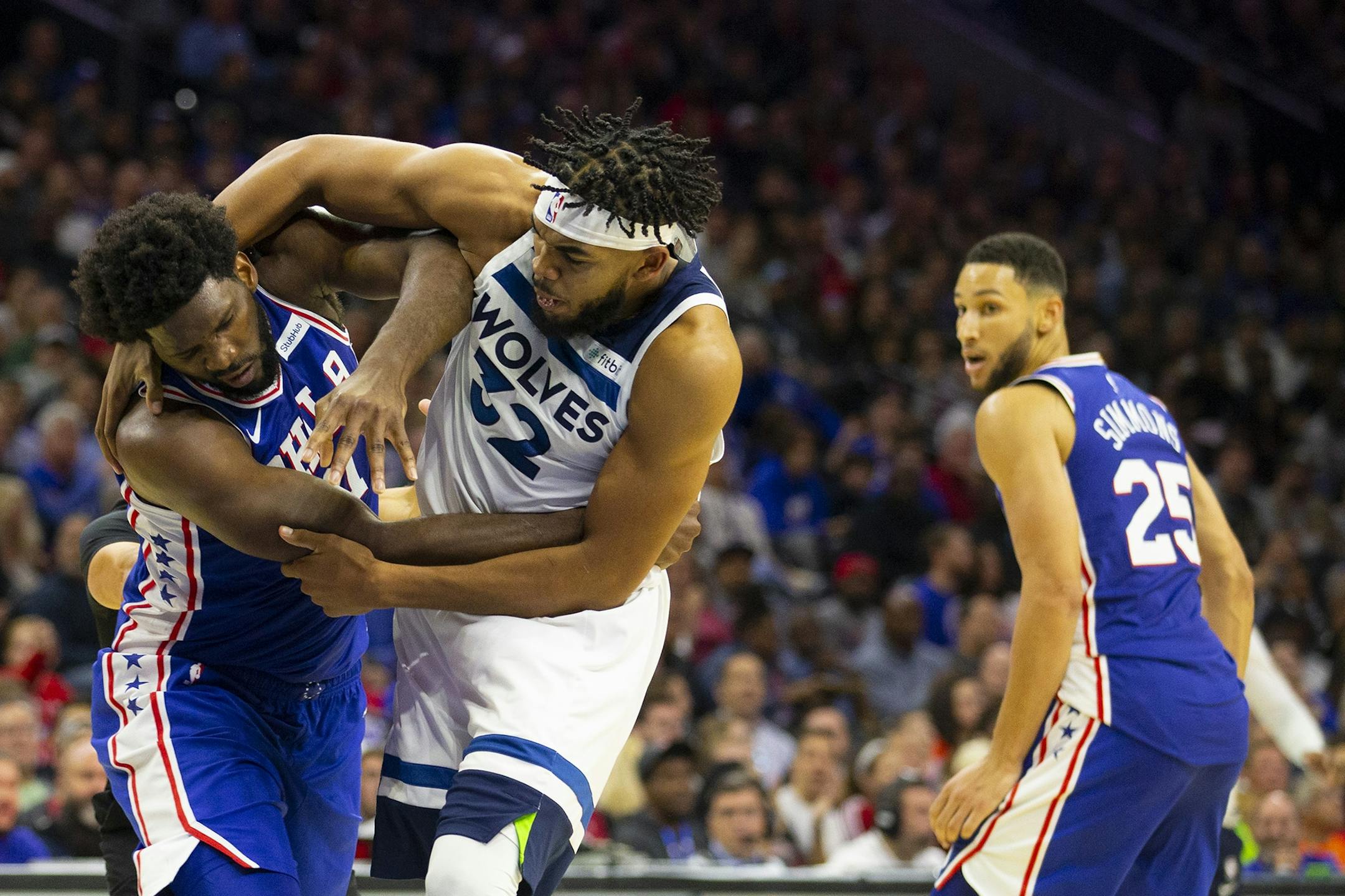 The Philadelphia 76ers' Joel Embiid, left, fights with the Minnesota Timberwolves' Karl-Anthony Towns (32)as Ben Simmons (25) looks on in the third quarter at the Wells Fargo Center in Philadelphia on Wednesday, Oct. 30, 2019.