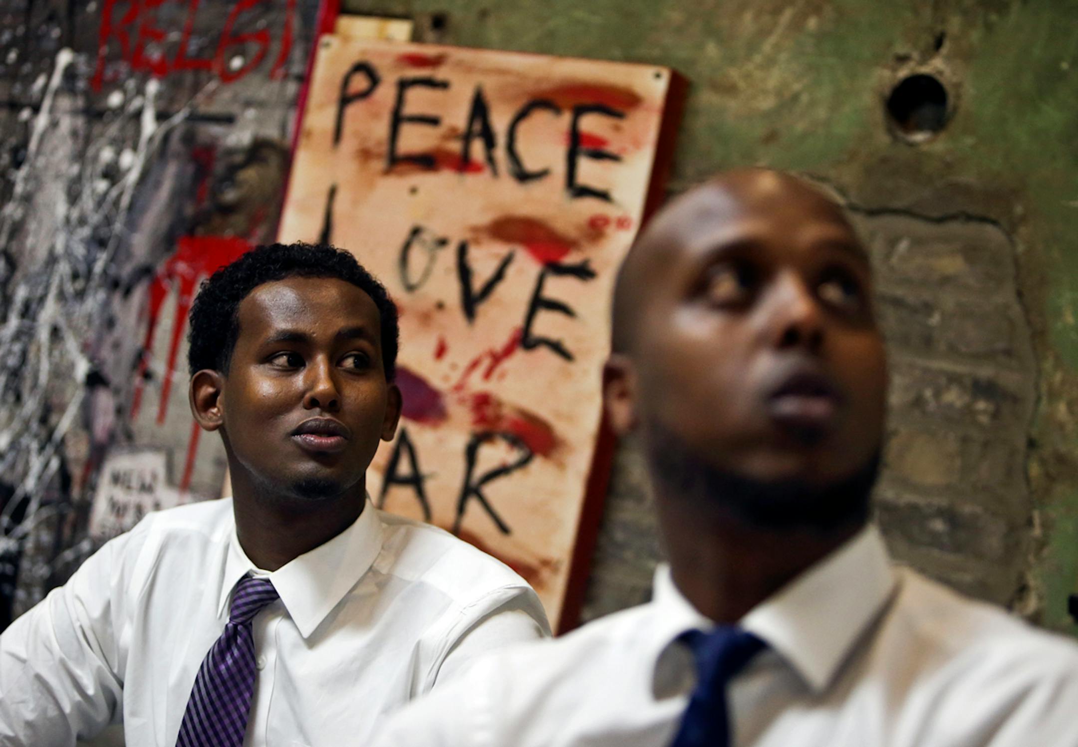 Abdifatah Farah, right, Ka Joog articistic director, and Daud Mohamed, Ka Joog vice president and special projects manager, look at at a hanging banner at the Ka Joog office, that says "no tribalism" Thursday, Sept. 26, 2013,in Minneapolis, MN. Ka Joog means "to stop" or "stay away" and according to members means away from terrorism, gangs, tribalism and other ills that have struck some of the Somali American youth. "Right now everyone's on the same page," Farah said, in recognizing that Al-Shab