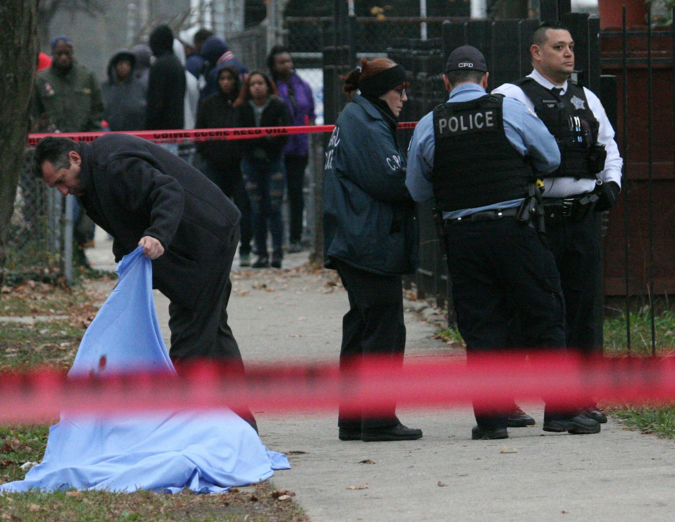Residents watch as Chicago Police investigate a fatal shooting at 3800 W. Adams Street on Nov. 27, 2016 in Chicago. (Eric Clark/Chicago Tribune/TNS)