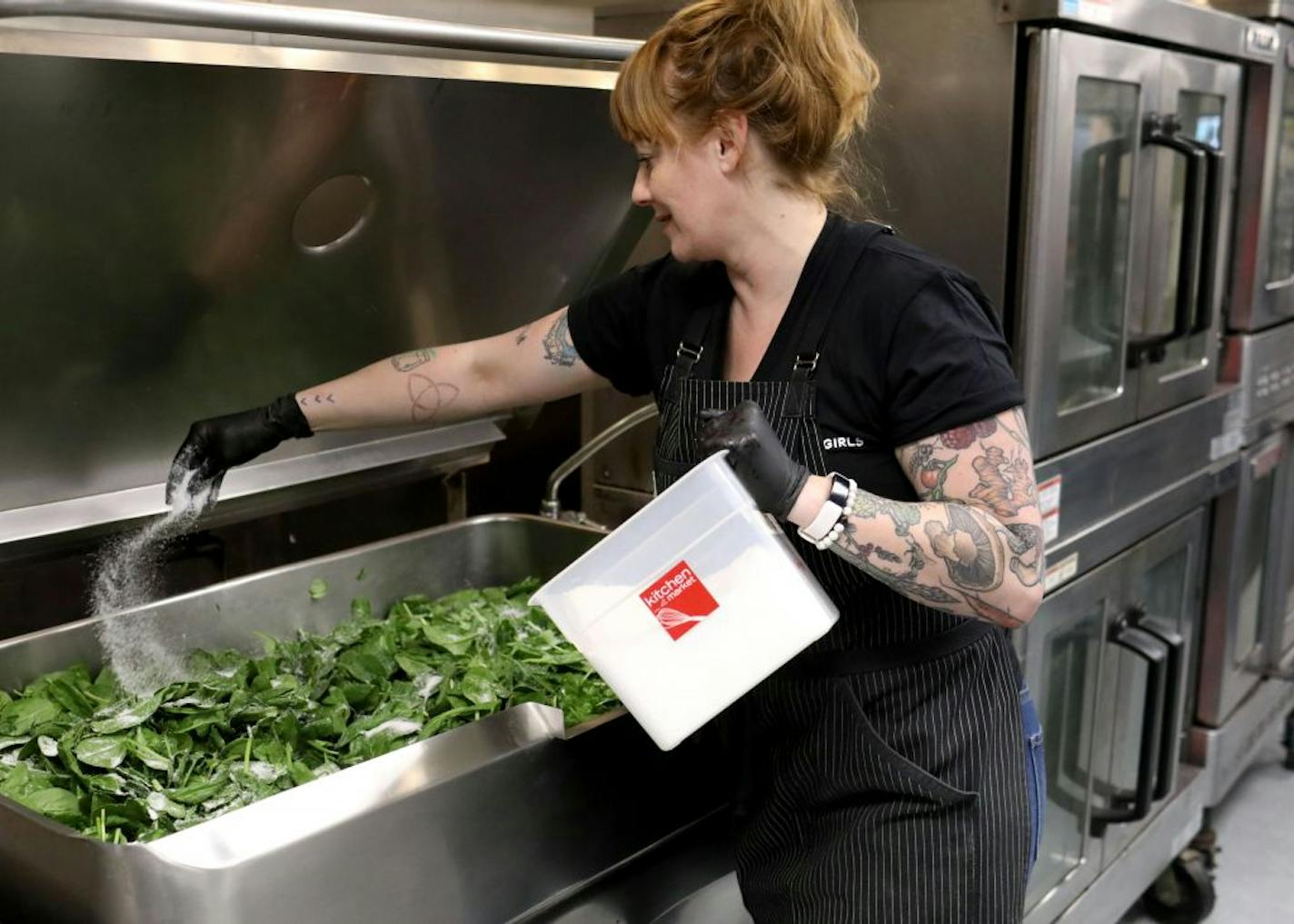 Arianna Baker-Kern, Chowgirls Killer Catering chef de cuisine, salts spinach in a tilt skillet for veggie lasagna that will be distributed by Loaves & Fishes to people in need Wednesday, March 18, 2020, in Minneapolis, MN. Much of the food came from Second Harvest Heartland's and much of that was collected from local restaurants that are now closed.