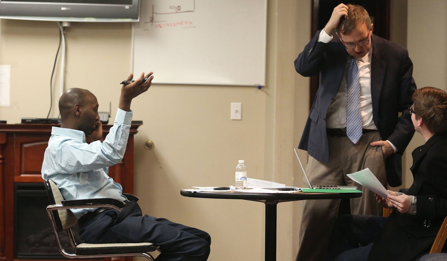 Mohamud Noor, leftt, talked to delegates while volunteers Matt Musel, middle, and Wil Bernstrom went over phone lists of undecided delegates in Minneapolis, Wednesday, February 5, 2014. ] (KYNDELL HARKNESS/STAR TRIBUNE) kyndell.harkness@startribune.com ORG XMIT: MIN1402052005040113