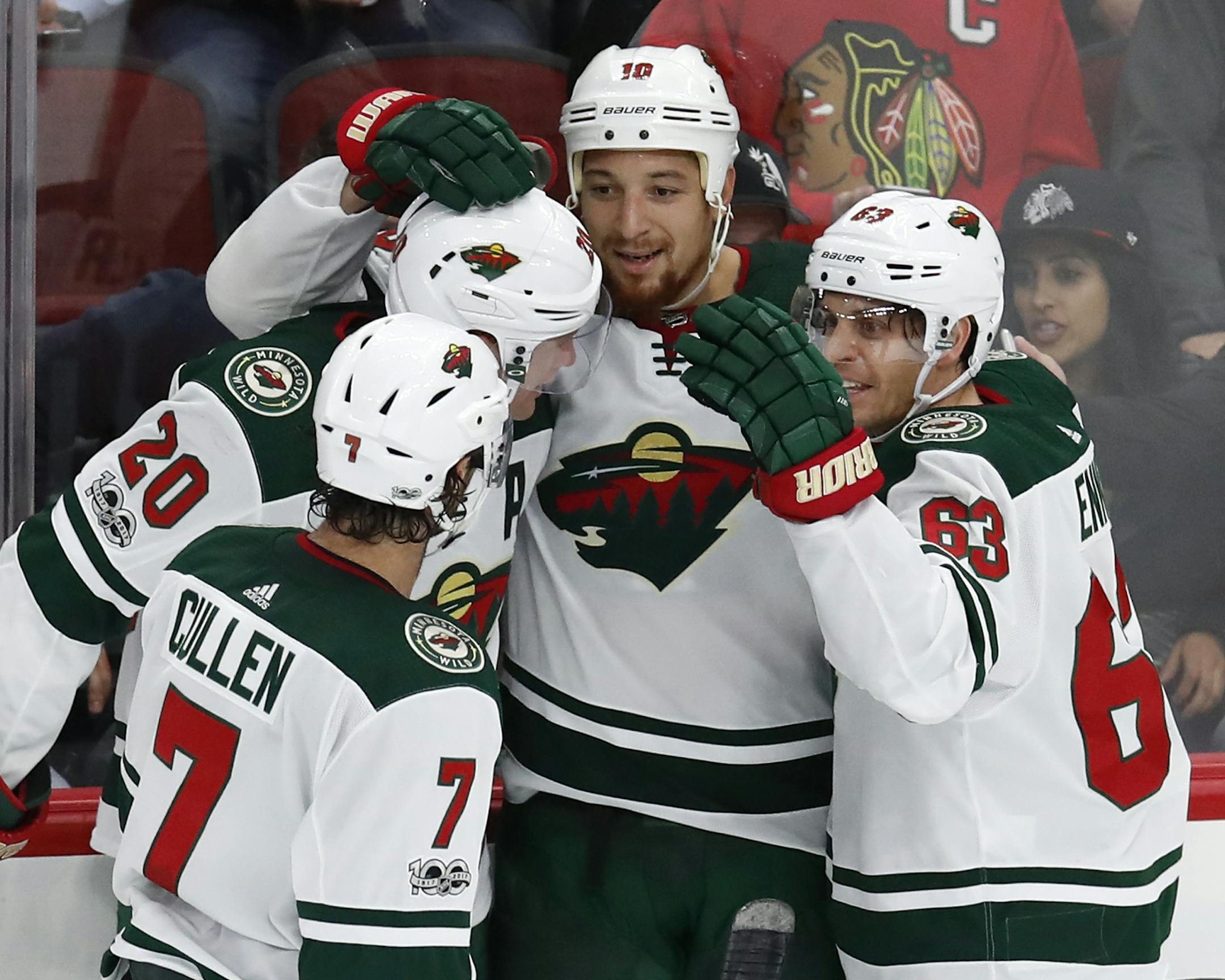 Minnesota Wild's Chris Stewart, center, celebrates his goal against the Chicago Blackhawks with teammates Matt Cullen (7), Ryan Suter (20) and Tyler Ennis (63) as Blackhawks' Brent Seabrook skates past during the third period of an NHL hockey game Thursday, Oct. 12, 2017, in Chicago. (AP Photo/Jim Young)