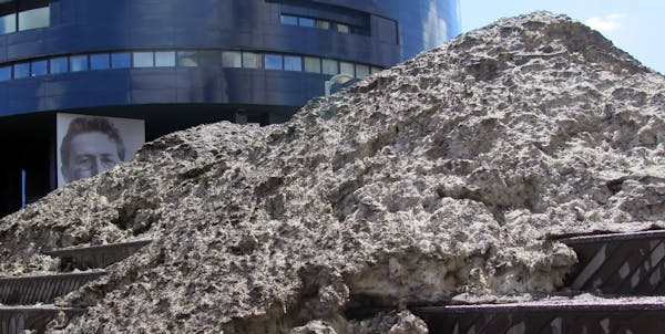 Snowbank - a small mountain of dirty snow slowly melts in the spring weather, -located on the plaza steps between the Guthrie theater and Mill Ruins P