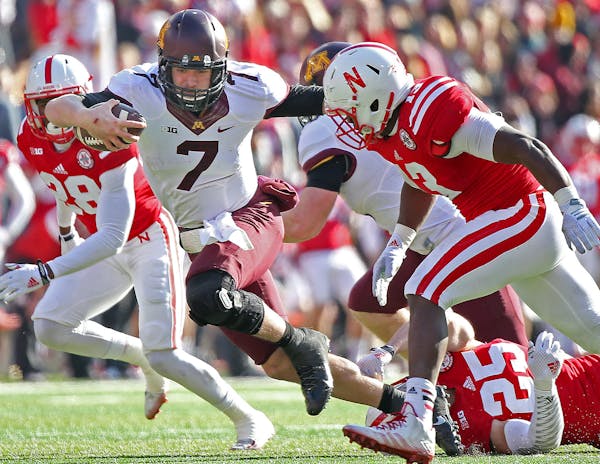 Minnesota's quarterback Mitch Leidner (7) ran for a first down despite defensive pressure by Nebraska's defensive back Nate Gerry (25) in the third qu