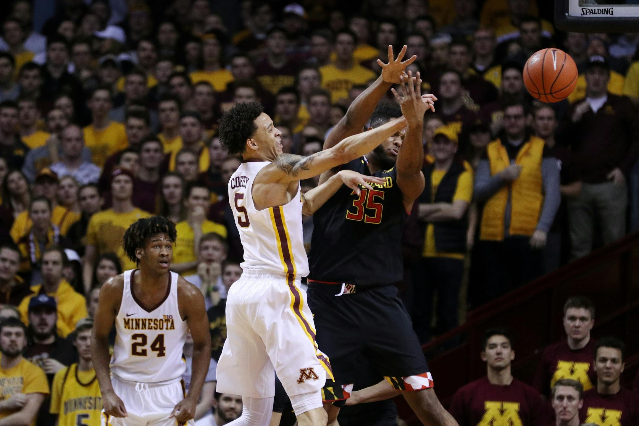 Minnesota Golden Gophers guard Amir Coffey (5) passes around Maryland Terrapins forward Damonte Dodd (35) during the first half.