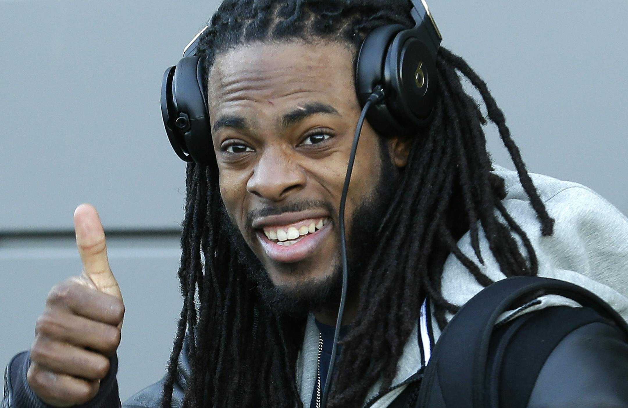 Seattle Seahawks cornerback Richard Sherman gives a thumbs-up as he leaves team's headquarters, Sunday, Jan. 26, 2014, in Renton, Wash., to board a bus for his flight to play the Denver Broncos in the NFL Super Bowl XLVIII football game in East Rutherford, N.J. (AP Photo/Ted S. Warren)