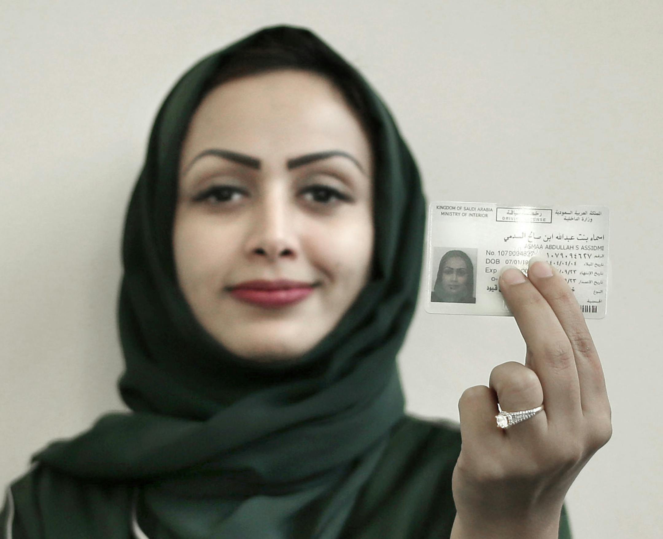FILE - In this June 23, 2018 file photo, 34-year old Asmaa al-Assdmi poses for a photograph holding her new car license at the Saudi Driving School inside Princess Nora University in Riyadh, Saudi Arabia. Saudi women are on the roads and steering their way through busy city streets freely for the first time after years of risking arrest if they dared to get behind the wheel. (AP Photo/Nariman El-Mofty, File) ORG XMIT: NM214